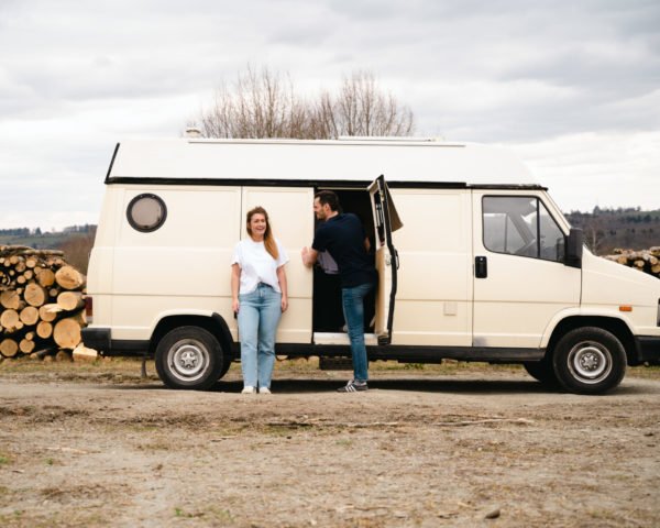 Photo d'un couple qui porte un t-shirt belge près d'un van